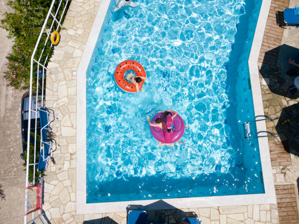 istock Three childrend on inflatable rings in swimming pool 1151105196