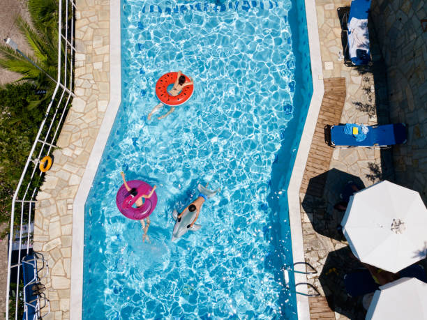 istock Three children playing in swimming pool on inflatable floats 1151105201