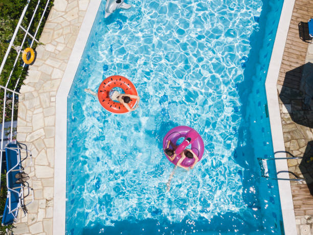 istock Three kids in the swimming pool on inflatable rings 1151105210