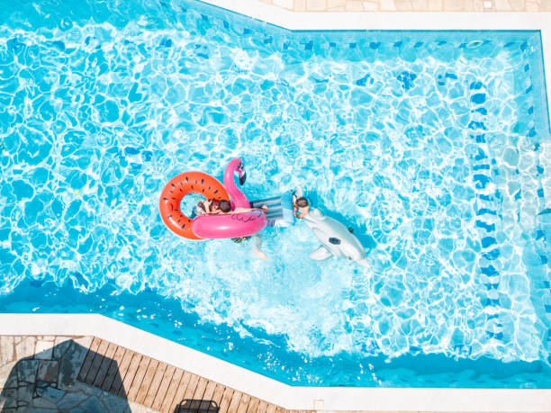 istock Three kids playing on inflatable floats in swimming pool 1151105252