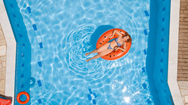 istock Woman in bikini enjoying on inflatable ring in the pool 1151105803