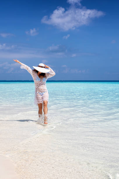 istock Happy woman walks on a beach with turquoise ocean 1151112925