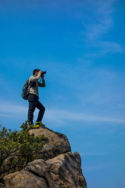 istock A photographer takes a picture on a rock 1151114152