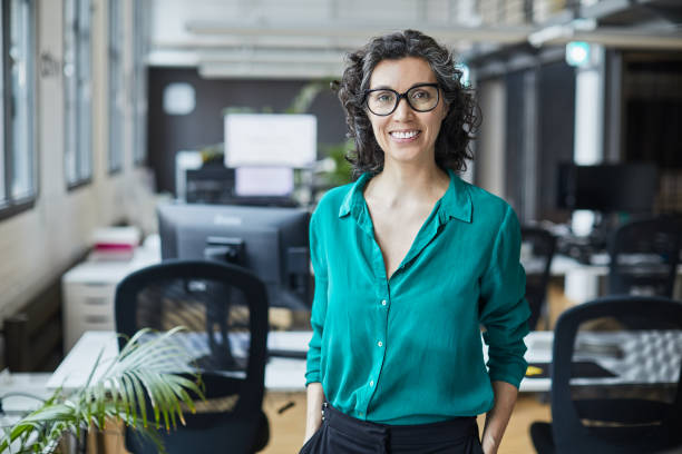 istock Business person portrait looking at camera. Standing in empty office with copy space. 1151114513