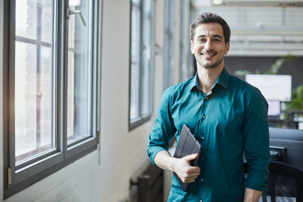 istock Business person portrait looking at camera. Standing in empty office with copy space. 1151114531