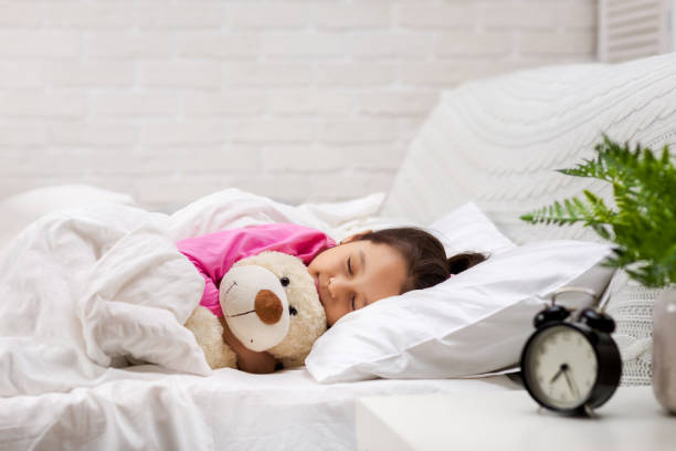 istock Cute little child girl sleeping with teddy bear 1151114736