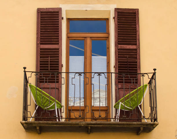 istock A balcony on the antic house with green two chairs, Italy 1151114842
