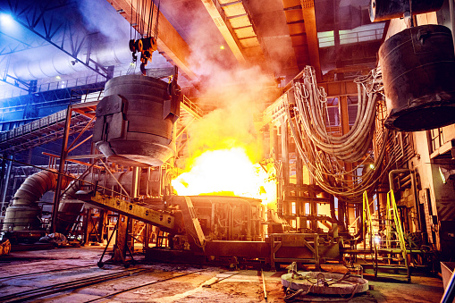 El metal chatarra se vierte en un horno de arco eléctrico en una fábrica de acero photo