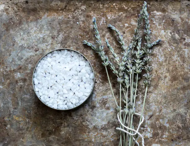Dried lavender flatlay on rustic background with bathsalt in a holder