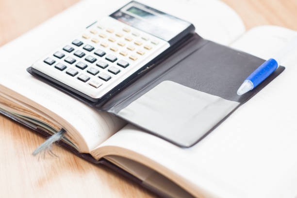 istock Close-Up Of Calculator And Book On Table 1151129518