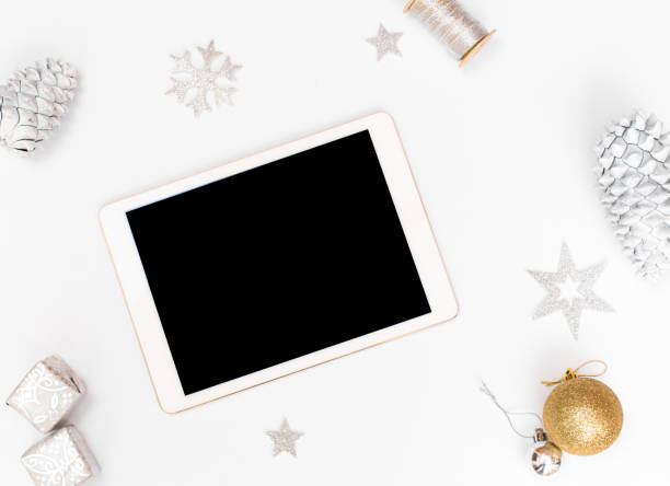 istock Computer laptop mobile display on table with isolated white screen for mockup in Christmas time. Christmas tree, gifts, decorations in background. 1151134342