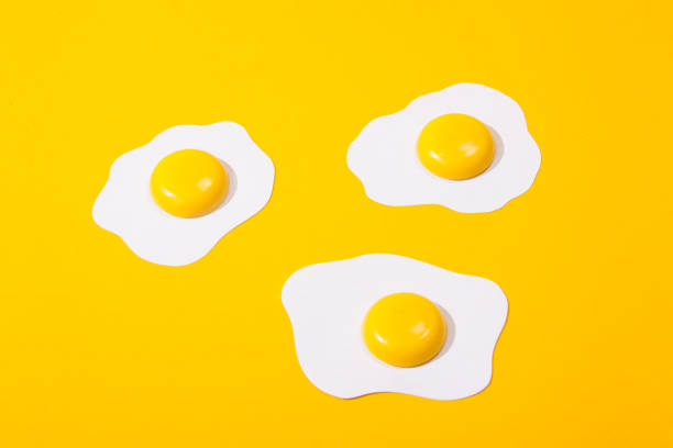 istock three paper scrambled eggs-fried eggs located on a yellow paper background. 1151134695