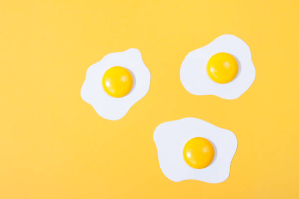 istock paper fried egg, set against a backdrop of yellow paper. Horizontal view over 1151134859