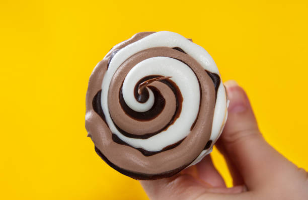 istock chocolate cream ice cream in waffle cone on yellow background. 1151135504