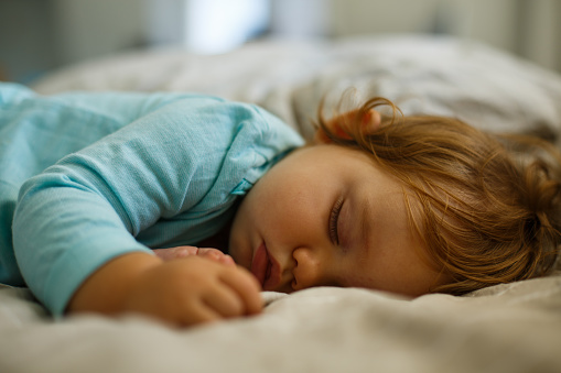 Cute baby girl sleeping on the bed.