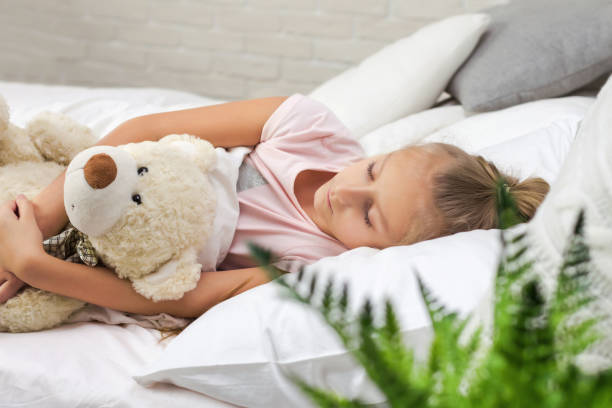 istock Cute little child girl sleeping with teddy bear 1151136770