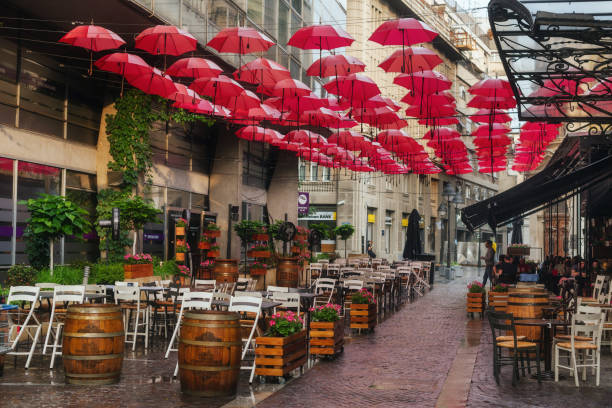 Street Cafe with Hanging Red Umbrellas Belgrade, Serbia - June 14, 2018. Outdoor restaurant decoration with hanging red umbrellas in Belgrade center. Popular touristic street cafe with summer terrace and parasols. rainy cafe stock pictures, royalty-free photos & images