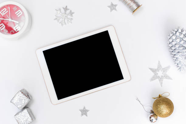 istock Computer laptop mobile display on table with isolated white screen for mockup in Christmas time. Christmas tree, gifts, decorations in background. 1151138495