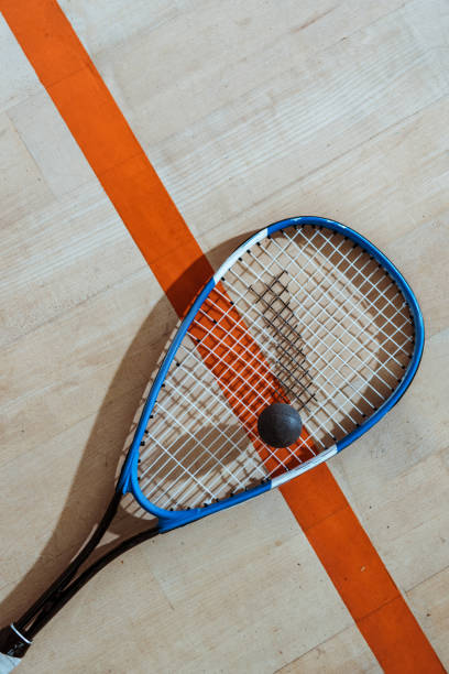 istock Top view of squash racket and ball on wooden surface 1151139309