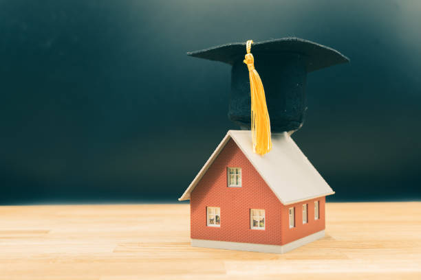 istock Concept for a smart home. A model house wears a graduation hat. 1151140764