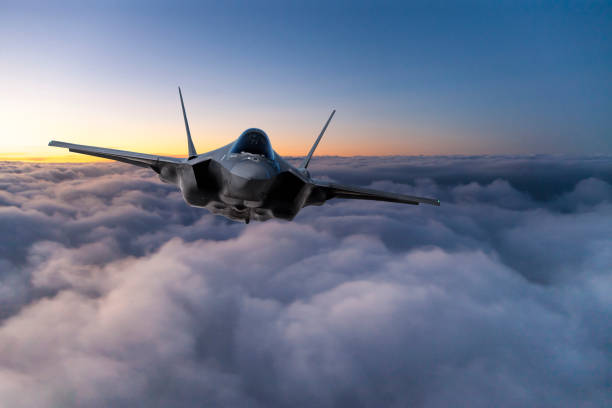 Fighter Jet flying over the clouds at sunset Fighter Jet flying over the clouds at sunset air attack photos stock pictures, royalty-free photos & images