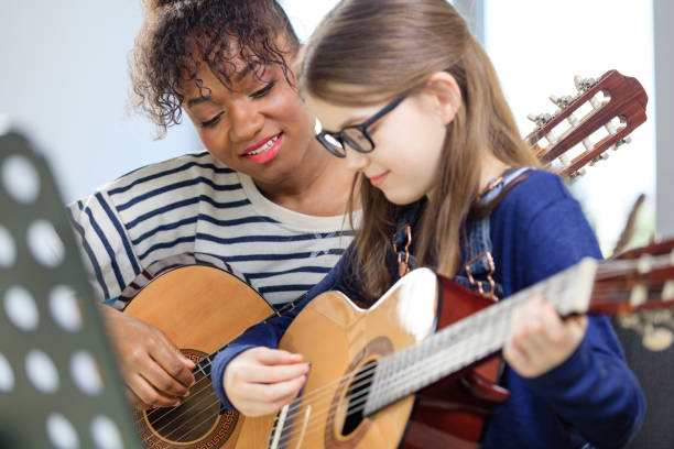 istock Music trainer teaching student plucking guitar 1151141589
