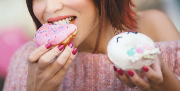 istock Unrecognizable young woman eating delicious donut. 1151141797