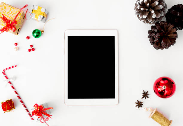 istock stylish tablet mockup for christmas time, christmas decorations on isolated white screen, flat lay top view. 1151143271