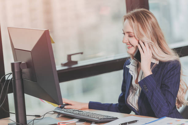 istock Businesswoman working in office with business phone call while using computer at office desk vintage color tone 1151144103