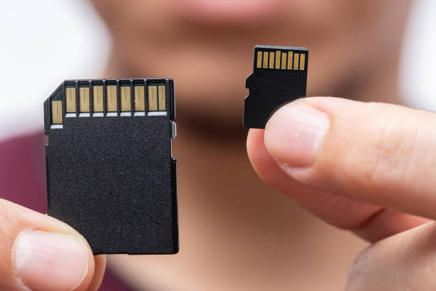 digital storage speichergröße materie konzept, sd card und micro sd-karte vergleichen im griff - memory card stock-fotos und bilder