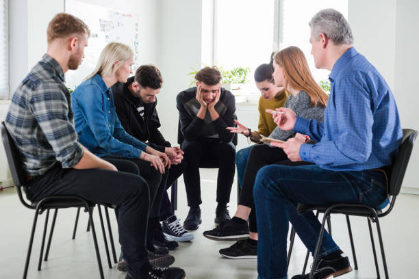 istock Sad man sitting in group therapy at lecture hall 1151145959