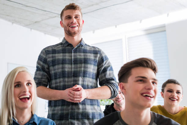 istock Smiling man standing by friends during meeting 1151146133