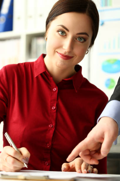 istock Female worker making notes in documents where male boss arm showing with finger 1151147365