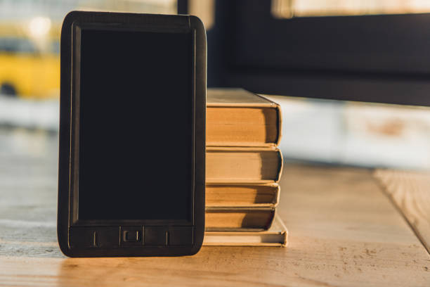 istock e-book with blank screen near paper books on table 1151147450