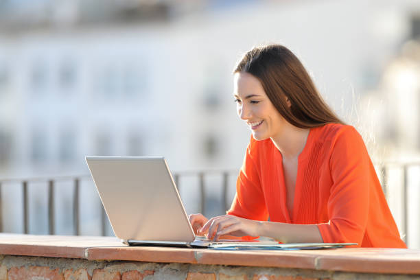istock Happy self employed working with a laptop in a balcony 1151149190