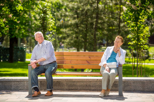 istock Senior couple sitting on bench in local park 1151149619
