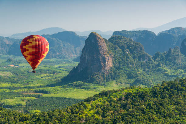 istock Hot air balloon flying over mountains in Asia 1151150862
