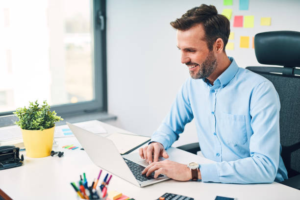 istock Happy businessman working on laptop at corporate office 1151150928