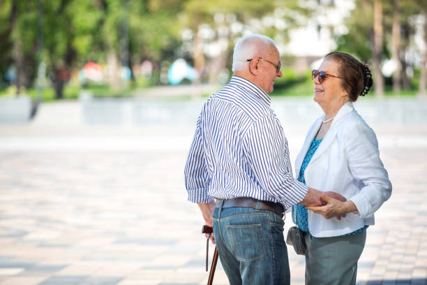 istock Senior adults walking in a park holding hands 1151151714