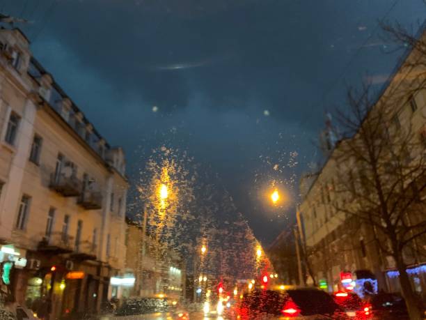 istock rainy weather, view from inside the car.  working wipers and raindrops at night 1151151872