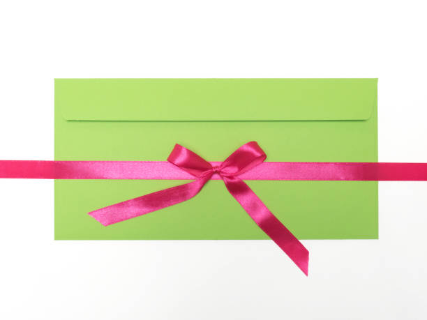fita cor-de-rosa do cetim horizontalmente com curva com envelope verde no fundo branco - red bauble audio - fotografias e filmes do acervo