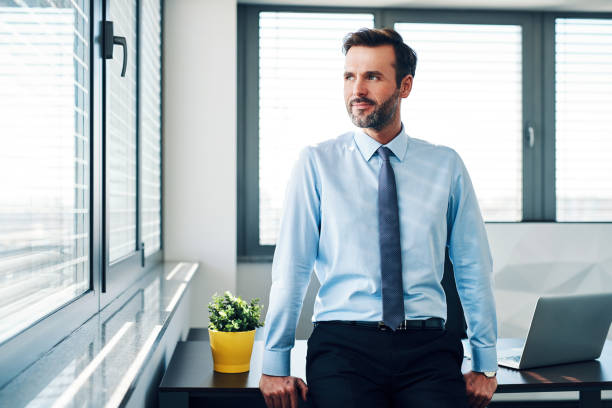 istock Successful businessman looking through the window in modern office 1151151946