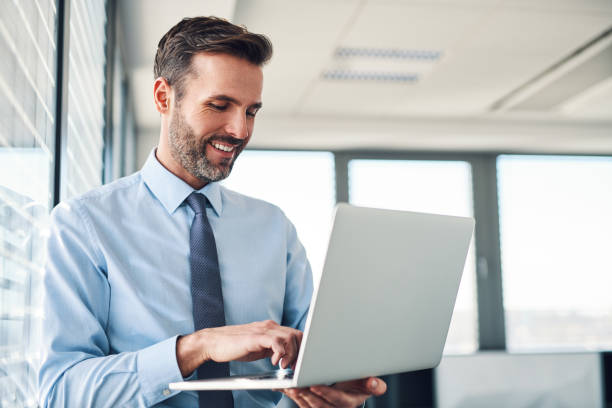 istock Handsome businessman in modern office working on laptop 1151152048