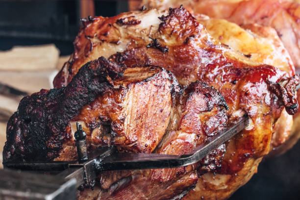 deliciosos jamones de cerdo cocinados en un fuego abierto - roasting spit fotografías e imágenes de stock