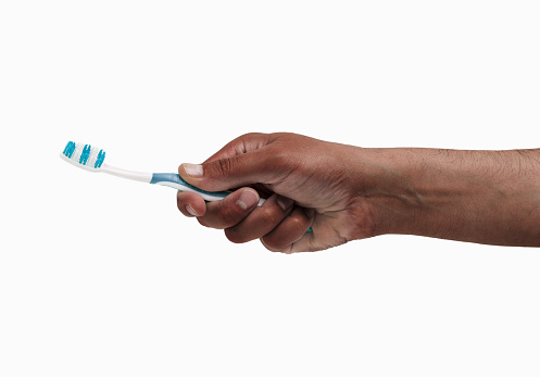 man hand holding a toothbrush isolated on a white background