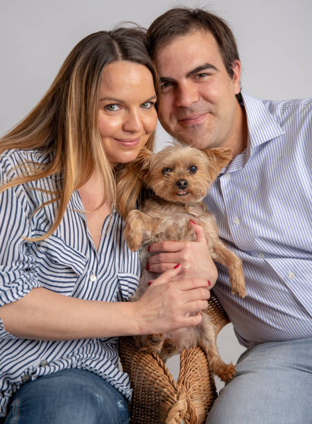 istock Young couple pose in a photography studio with his yorkshire dog. 1151153339