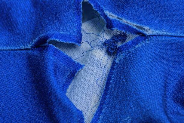 un pezzo di abbigliamento brandelli con un grande buco bianco sulla materia - textile burlap sewing patch foto e immagini stock