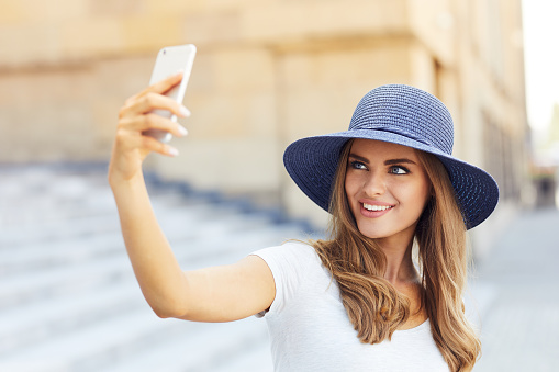 Beautiful woman taking selfie while standing outdoors