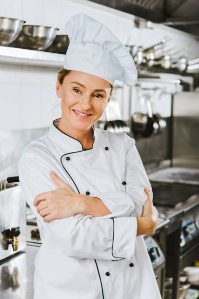 istock attractive female chef in uniform with arms crossed looking at camera in restaurant kitchen 1151155834