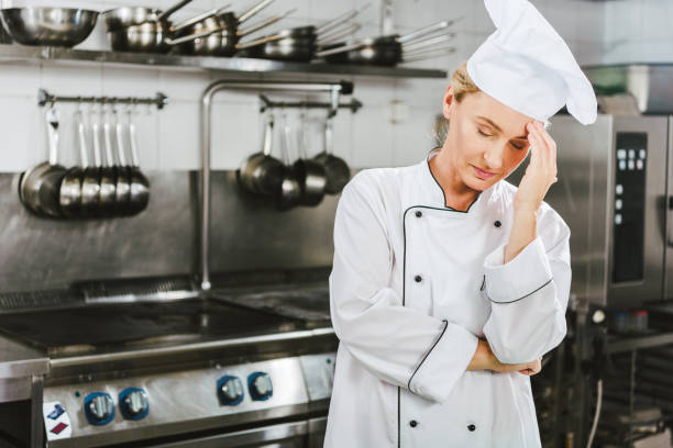 istock beautiful tired female chef in uniform having headache in restaurant kitchen with copy space 1151155840